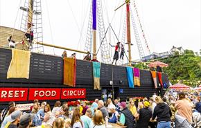 Pirate circus performers entertain the Street Food Circus crowds from the rigging of the replica sailing ship at Saundersfoot harbour
